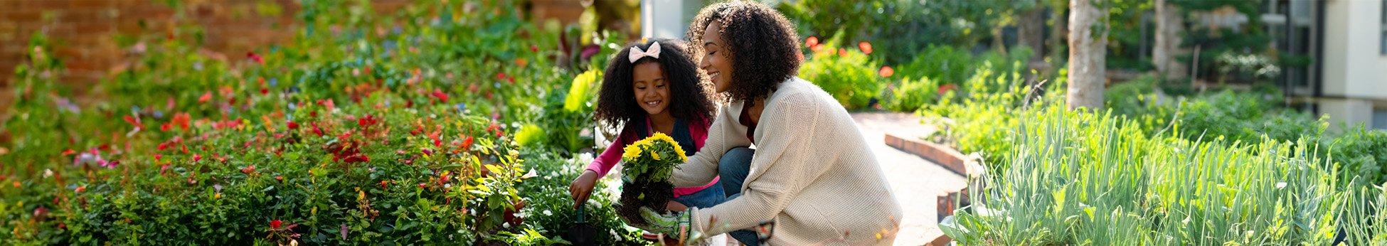 Mãe e filha cuidando do jardim